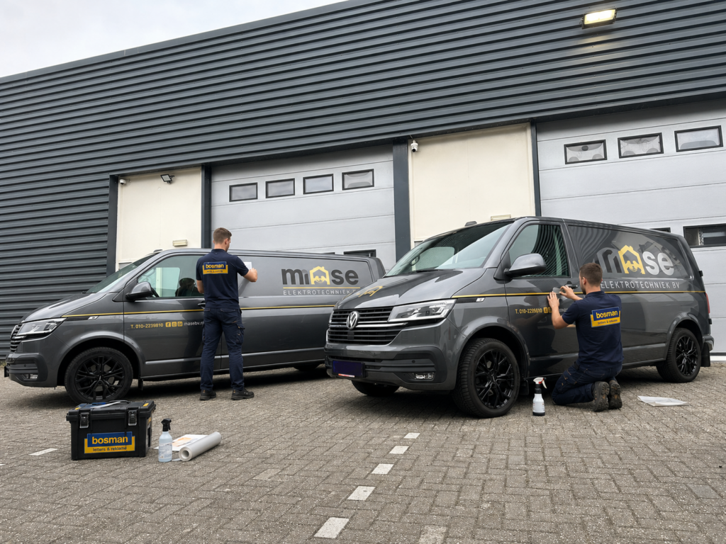 Bosman monteurs brengen autobelettering aan