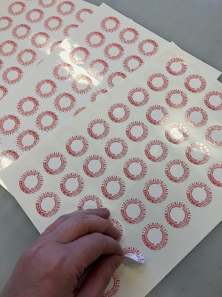 Keuringsstickers op vel. Laten zien dat je de stickers van de vel kunt pellen.